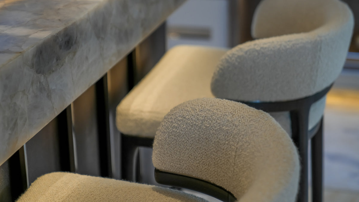 Detail of Sitdesign bar stools on Al Reem — bouclé upholstery