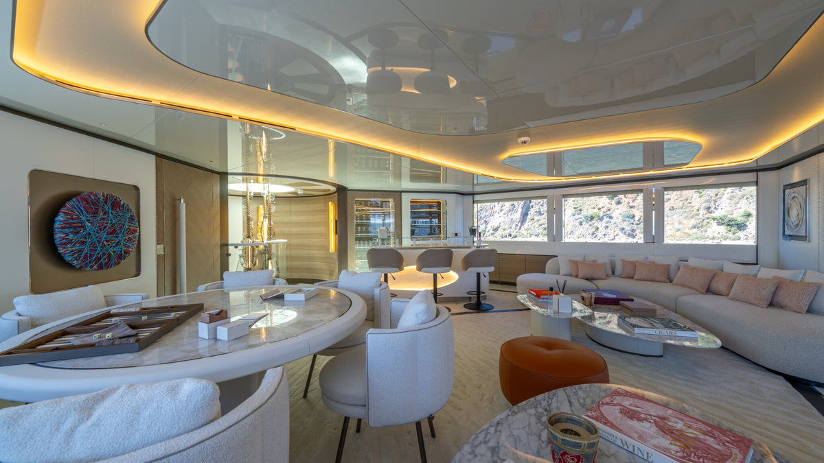 CAMILA upper saloon — games table, bar stools and sofa along the window line