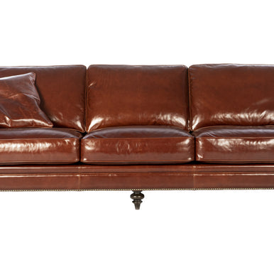 Divano Chelsea in pelle color cognac con tre cuscini di seduta e cuscino decorativo, vista frontale