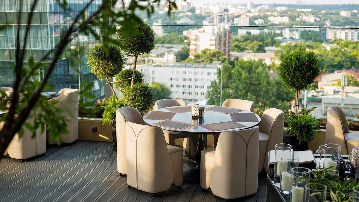 Rooftop terrace dining table with cream upholstered tub chairs and city view, Radisson Blu Leogrand