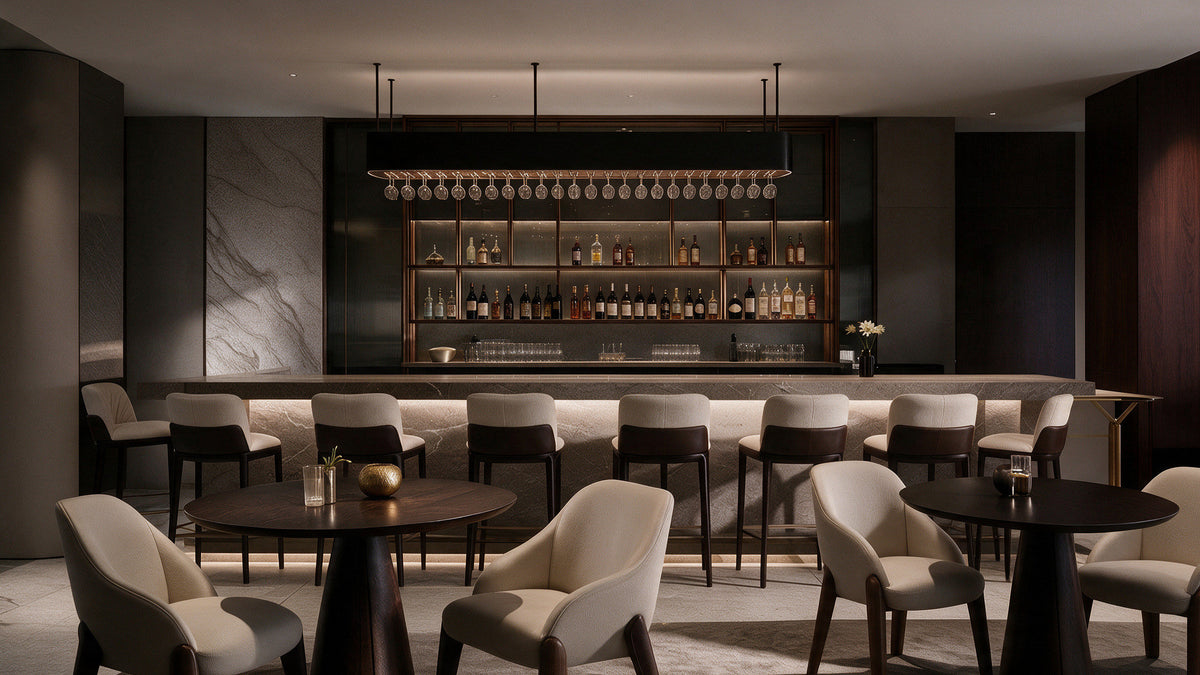 Hotel bar with upholstered bar stools and cream tub chairs around dark wood tables, Radisson Blu Leogrand