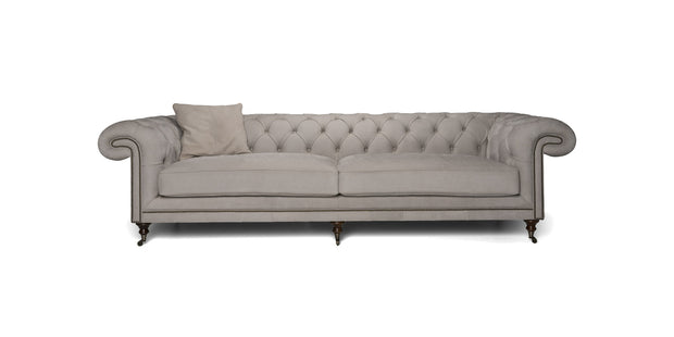 Divano Cambridge grigio chiaro con schienale capitonné, borchie e cuscino decorativo, vista frontale