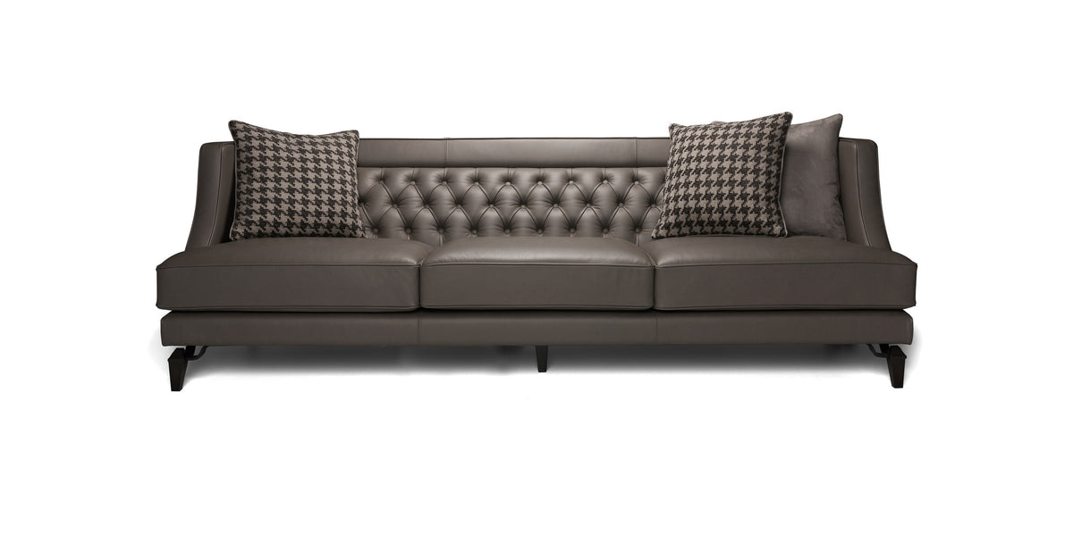 Divano Charlotte in pelle grigio scuro con schienale capitonné e cuscini decorativi, vista frontale