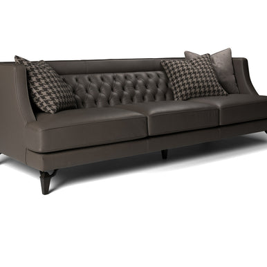 Divano Charlotte in pelle grigio scuro con schienale capitonné e cuscini decorativi, vista di tre quarti