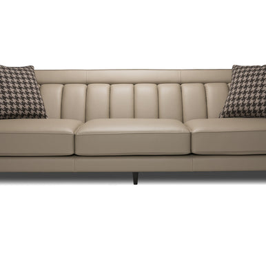 Divano Charlotte in pelle tortora con schienale a cuciture verticali e cuscini decorativi, vista frontale