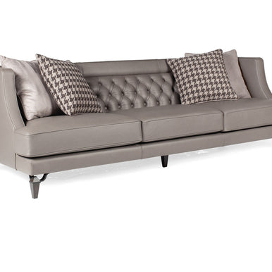 Divano Charlotte in pelle grigio chiaro con schienale capitonné e cuscini decorativi, vista di tre quarti