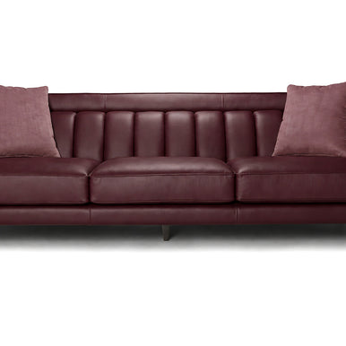 Divano Charlotte in pelle bordeaux con schienale a cuciture verticali e cuscini decorativi, vista frontale