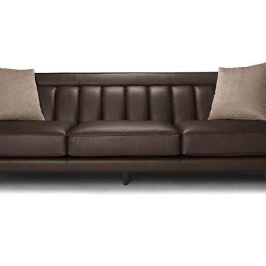 Divano Charlotte in pelle marrone scuro con schienale a cuciture verticali e cuscini decorativi, vista frontale