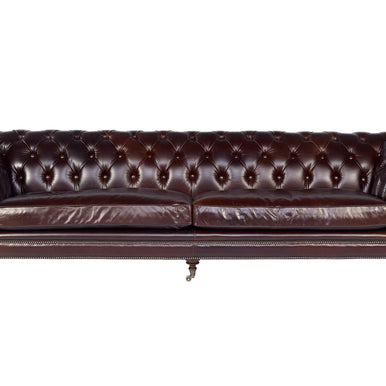 Jakarta chesterfield sofa in oxblood leather with button-tufted back, rolled arms, nailhead trim and turned legs on castors, front view