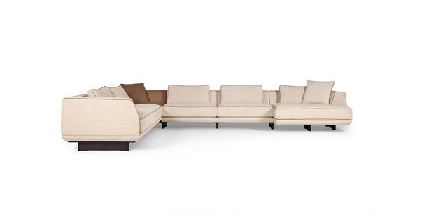Ranchero sectional sofa in cream fabric with brown accent cushions, corner view
